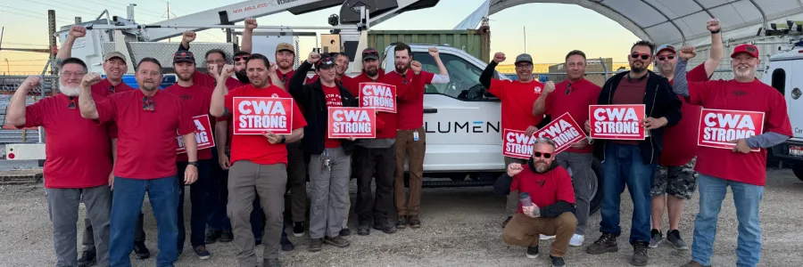 Lumen workers wearing red and holding CWA signs stand in front of Lumen truck